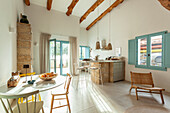 Bright living room with wooden beamed ceiling and open-plan kitchen in natural colours