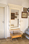 Wooden bench, wall mirror with decorations and pictures in the entrance area