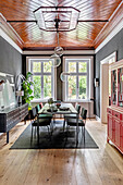 Dining room with wooden ceiling, modern dining table and black walls