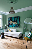 Living room with mint green walls and modern tapestry