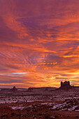 Colorful sunset skies over Monument Valley in the Monument Valley Navajo Tribal Park in Utah & Arizona.