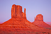 The Mittens in post-sunset pastel in the Monument Valley Navajo Tribal Park in Arizona.