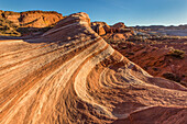 The Fire Wave, a red & white striped Aztec sandstone formation at sunset in Valley of Fire State Park in Nevada.