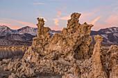 Tufa formations in Mono Lake in California at sunset with the Eastern Sierra Mountains in the background.