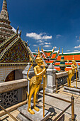 Golden statue of a Singhaphanon mythical creature guards the Phra Wiharn Yod in the Grand Palace complex in Bangkok, Thailand. A Singhaphanon has the upper body of a monkey and lower body of a lion.