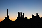 The Totem Pole and the Yei Bi Chei in silhouette before dawn in the Monument Valley Navajo Tribal Park in Arizona.