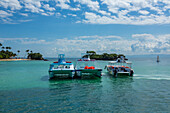 Ausflugsboote vor der Küste von Cayo Levantado, einer Ferieninsel in der Bucht von Samana in der Dominikanischen Republik