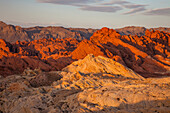 Roter und weißer Azteken-Sandstein im Fire Canyon bei Sonnenaufgang im Valley of Fire State Park in Nevada. Der weiße Sandstein wird Silica Dome genannt. Seine Sandkristalle sind fast reine Kieselsäure.