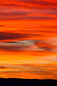Fiery red clouds at sunset over the canyon country near Moab, Utah.