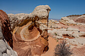 Colorful eroded Navajo sandstone in the White Pocket Recreation Area, Vermilion Cliffs National Monument, Arizona. Plastic deformation is shown here. Lollipop Rock is in the distance.