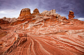 Stormy clouds over colorful eroded sandstone formations. White Pocket Recreation Area, Vermilion Cliffs National Monument, Arizona.