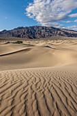Wellen in den Sanddünen von Mesquite Flat im Death Valley National Park in der Mojave-Wüste, Kalifornien. Dahinter die Panamint Mountains