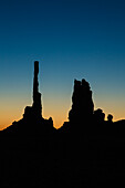 The Totem Pole and the Yei Bi Chei in silhouette before dawn in the Monument Valley Navajo Tribal Park in Arizona.