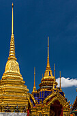 Vergoldeter Pavillon und goldener Chedi, gestützt von Dämonen, am Tempel des Smaragdbuddhas im Grand Palace in Bangkok, Thailand