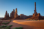 The Totem Pole & Yei Bi Chei with rippled sand dunes in the Monument Valley Navajo Tribal Park in Arizona.