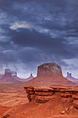 Stormy view of Monument Valley from John Ford Point in the Monument Valley Navajo Tribal Park in Arizona. L-R: Sentinal Mesa with the West Mitten in front, Big Indian Chief obscured by cloud, Merrick Butte, the Castle, and the Stagecoach. John Ford Point is in the foreground.