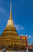 Golden Chedi supported by demons by the Temple of the Emerald Buddha at the Grand Palace complex in Bangkok, Thailand.