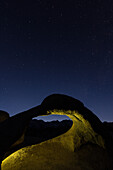 Sterne über dem Mobius Arch in den Alabama Hills bei Lone Pine, Kalifornien, mit der Silhouette des Mt. Whitney unter dem Bogen