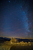 Milky Way over tufa formations in Mono Lake in California with stars reflected in the lake.