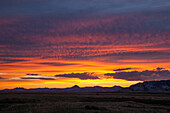 Farbenfrohe Wolken bei Sonnenuntergang über den Granite Mountains in Wyoming, U.S.A.