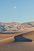 Untergehender Mond über den Sanddünen von Mesquite Flat und den Panamint Mountains im Death Valley National Park in der Mojave-Wüste, Kalifornien