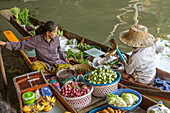 Soziale Interaktion zwischen thailändischen Verkäufern auf ihren Booten auf dem schwimmenden Markt von Damnoen Saduak in Thailand