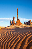 The Totem Pole & Yei Bi Chei with rippled sand in the Monument Valley Navajo Tribal Park in Arizona.
