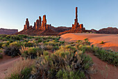 Erstes Licht auf den Totempfahl und Yei Bi Chei mit gewellten Sanddünen im Monument Valley Navajo Tribal Park in Arizona