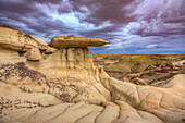 Sandstone caprocks on hoodoos in the colorful clay hills in the badlands of the San Juan Basin in New Mexico.