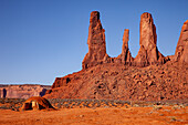 A traditional Navajo hogan in front of the Three Sisters in the Monument Valley Navajo Tribal Park in Arizona.