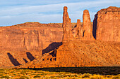The Three Sisters, sandstone monoliths at the edge of Mitchell Mesa in the Monument Valley Navajo Tribal Park in Arizona.