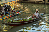 Thai vendors on their boats in the Damnoen Saduak Floating Market in Thailand.