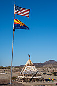 Flags over the grave memorial of Hadji Ali, or Hi Jolly, in the cemetary in Quartzsite, Arizona, with the Dome Rock Mountains behind.