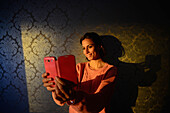 Young woman takes a selfie with mobile phone in hotel room, Kemi, Lapland