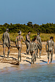 Menschen genießen ein Schlammbad auf Espalmador, einer kleinen Insel im Norden von Formentera, Balearen, Spanien