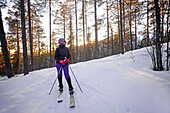 Junge Frau beim Altai-Skifahren im Skigebiet Pyha, Lappland, Finnland