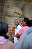 Visitors at Gal Vihara, also known as Gal Viharaya and originally as the Uttararama, rock temple in The Ancient City Polonnaruwa, Sri Lanka