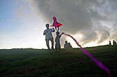 Junger Junge spielt mit einem Drachen bei Sonnenuntergang im UNESCO-Weltkulturerbe Galle Fort während des Binara-Vollmond-Poya-Tages