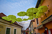 Regenschirme schmücken die Straßen von Szentendre, einer Stadt am Flussufer im Komitat Pest, Ungarn,