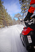 Antti, young Finnish guide from VisitInari, rides a snowmobile in the wilderness of Inari, Lapland, Finland