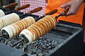 K?rt?skal?cs oder Schornsteinkuchen. Traditionelle Kostüme und Volksbräuche beim Osterfest in Holl?k?, einem zum UNESCO-Welterbe gehörenden Dorf in den Cserh?t-Hügeln des nördlichen Mittelgebirges, Ungarn