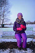 Junge Frau benutzt ein Mobiltelefon im Winter