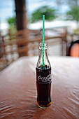CocaCola-Flasche mit Strohhalm auf einem Restauranttisch, Sri Lanka
