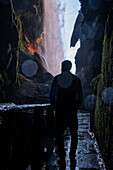 Junger Mann in einer Höhle im Naturpark Monasterio de Piedra, der sich um das Monasterio de Piedra (Steinkloster) in Nuevalos, Zaragoza, Spanien, erstreckt