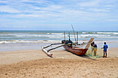 Fischer und traditionelle Fischerboote in Weligama, Sri Lanka