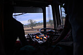 Silhouette von Fahrer und Schaffner vor einem nächtlichen Bus, Sri Lanka