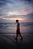 Young woman enjoying sunset at Hikkaduwa beach, Sri Lanka