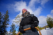 Young woman driving sledge. Wilderness husky sledding taiga tour with Bearhillhusky in Rovaniemi, Lapland, Finland