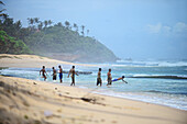 Eine Gruppe junger Männer amüsiert sich am Strand von Midigama, Sri Lanka