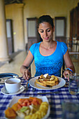 Young attractive woman having breakfast in The Dutch House hotel, Galle, Sri Lanka
